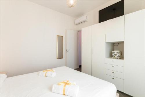 a bedroom with a white bed with two towels on it at GuestHost - Salento Sole e Mare Luxury with Pool in Lendinuso