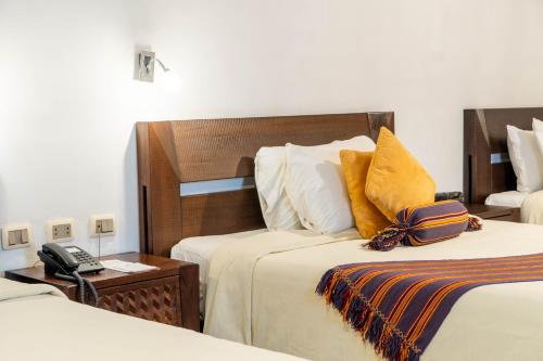 a hotel room with two beds and a telephone at La Casona Hotel Boutique in La Paz