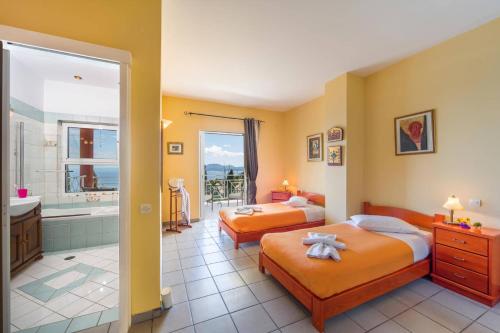 a bedroom with two beds and a bathroom with a shower at Villa Vrysoulla by Villa Plus in Nisakion