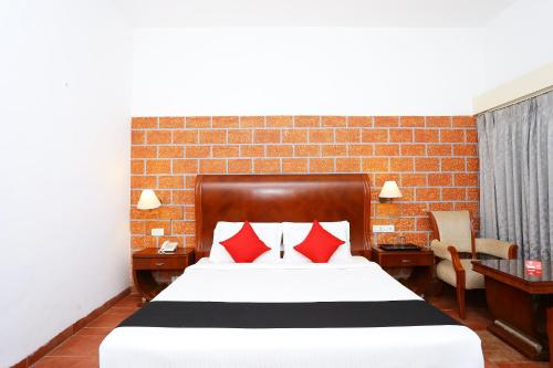 a bedroom with a large bed with red pillows at Super Townhouse Island Inn in Cochin