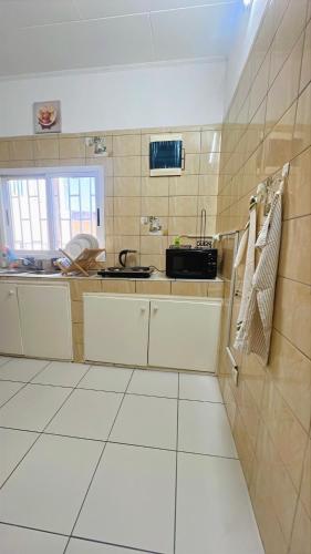 a small kitchen with a sink and a refrigerator at Studio Laluciole Louis in Libreville