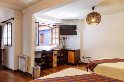 a room with a bed and a kitchen with a table at La Casona Hotel Boutique in La Paz