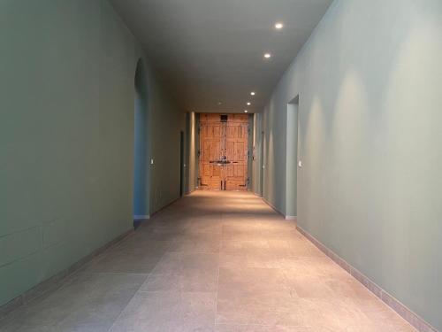 an empty hallway with a wooden door and a hallwayngth at Casa Tina in Ravenna