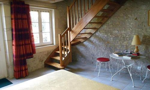 une pièce avec un escalier, une table et des chaises dans l'établissement La tonnelle de Thoré, à Civray-de-Touraine