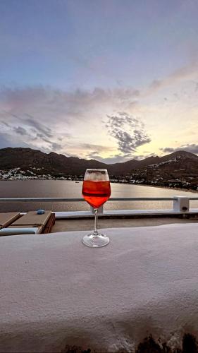 a glass of wine sitting on a table near the water at Amfitriti Serifos in Livadion