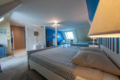 a bedroom with a large bed and blue walls at Au Puy Des Vérités in Lapalisse