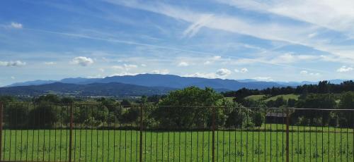 a fence in a field with mountains in the background at Gîte de Riosset in Grane