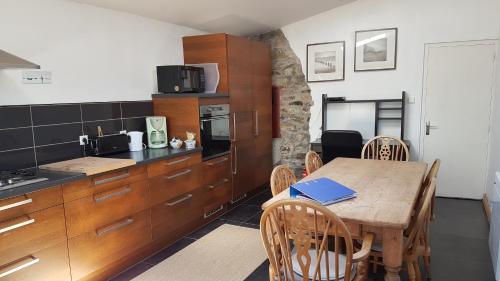 une cuisine avec une table en bois et une salle à manger dans l'établissement Camaret maison grand jardin, à Camaret-sur-Mer