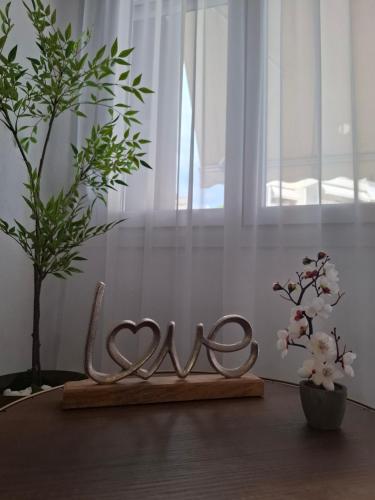 two metal hearts on a table next to two plants at Serenity in Kavala