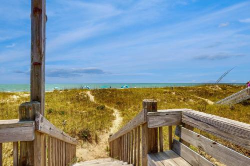 a wooden boardwalk leading to a beach with the ocean at Beachy Keen in Holden Beach