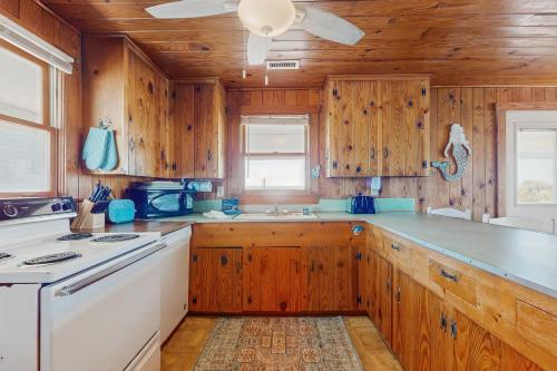 a kitchen with wooden cabinets and a white appliance at Beachy Keen in Holden Beach