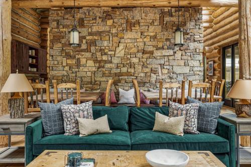 a living room with a green couch and a brick wall at Wilder Woods in Michiana