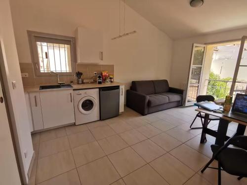 une cuisine et un salon avec une machine à laver dans l'établissement Augusta Résidence du Port - Magnifique - à 50 m du vieux Port et des animations, à La Ciotat