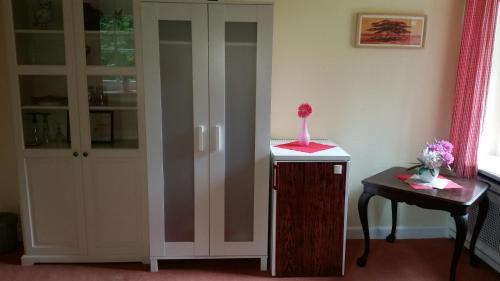 a room with a cabinet and a vase on a table at Zimmer mit Teichblick in Wiedenborstel