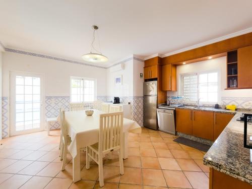 a kitchen with a table and chairs in a room at Casa Marina V4 by YHA in Tavira