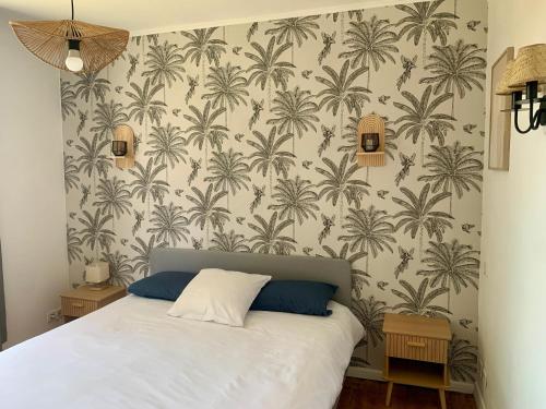 a bedroom with a bed with palm trees wallpaper at La villa Jeanne- Charmante maison avec très belle terrasse couverte à 10 min du centre de Salies de Bearn in Lahontan