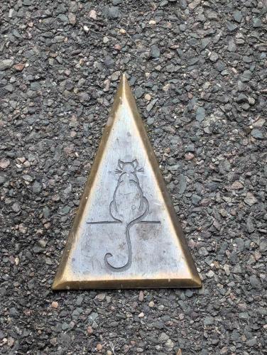 a metal triangle with a drawing of a mouse on the ground at péniche Ino Lefkothea II chambre d'hôtes in Dole