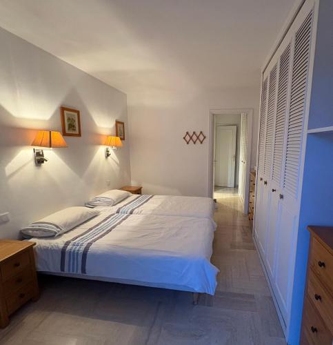 une chambre avec un grand lit blanc avec deux lampes dans l'établissement Appartement vue & front de mer, piscines, 55M2 2Pièces, à Cannes