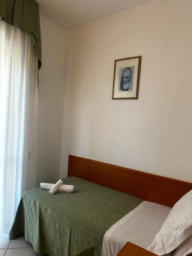 a bedroom with a bed and a picture on the wall at Hotel San Francesco in San Giovanni Rotondo