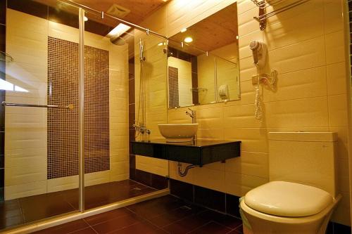 a bathroom with a toilet and a sink and a shower at Tranquil Sea Hotel in Kenting