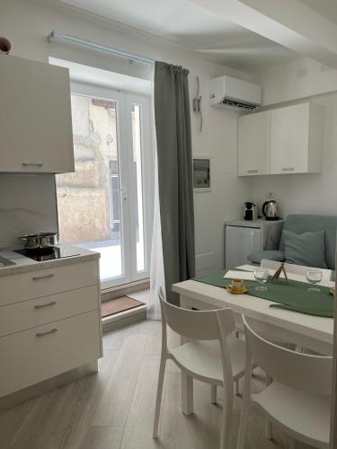 トロペアにあるChez-Nous Apartments by Bonsaiのキッチンにテーブルと椅子がある