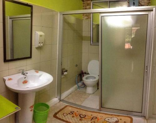 a bathroom with a shower and a sink and a toilet at sleepy hollow guesthouse in Pantai Cenang