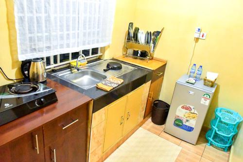 eine kleine Küche mit Spüle und Kühlschrank in der Unterkunft Victorious Place in Kitale