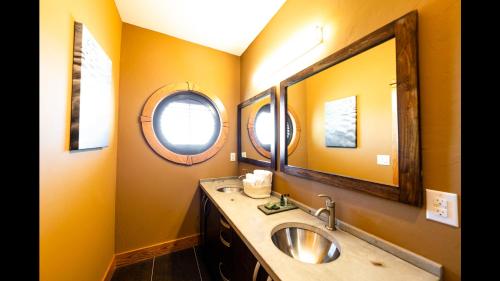 a bathroom with a sink and a mirror at S-Turns - 3-Bedroom, 3-Bathroom Suite at REAL Watersports in Waves