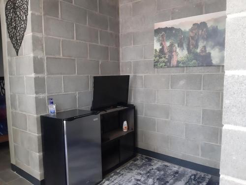 a black refrigerator in a room with a brick wall at Moderno Departamento Ejecutivo frente a Explanada in Pachuca de Soto
