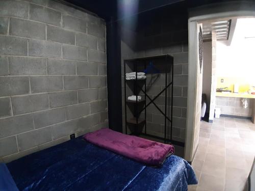 a bed in a room with a brick wall at Moderno Departamento Ejecutivo frente a Explanada in Pachuca de Soto