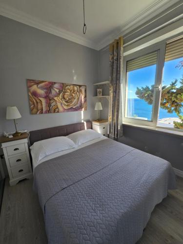a bedroom with a large bed and a large window at Beach apartment Suzy&Demi in Split