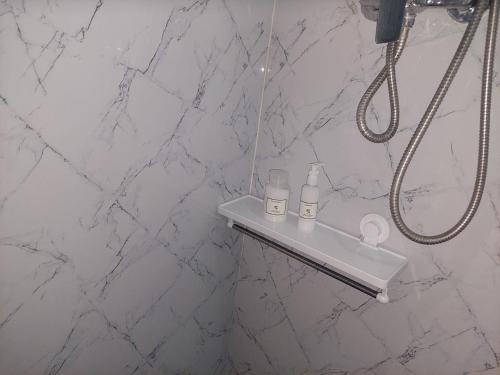 a bathroom with a shower with white marble walls at Quinta Flor Dos Lagos - Eco Tiny Hause in Torre de Moncorvo