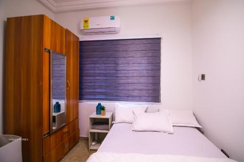 a bedroom with a white bed and a window at Cozy Luxury - East Legon Apt - WiFi, Netflix & AC in Accra
