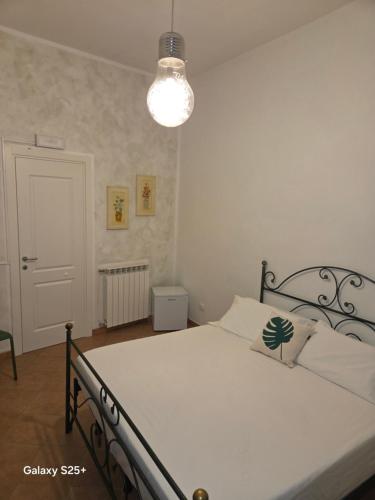 a bedroom with a white bed with a lamp at Nostra casa rooms in Palermo