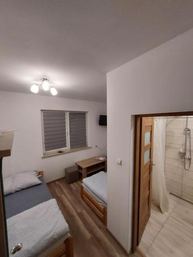 a small bedroom with a bed and a bathroom at Leśna Skałka in Bobolice