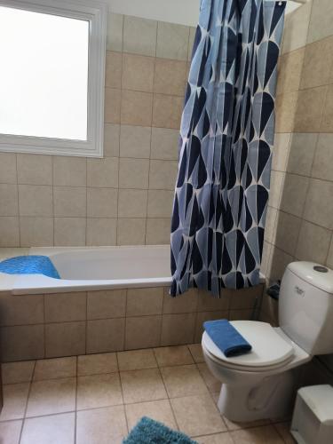 a bathroom with a tub and a toilet and a window at 3 Bedroom Affordable Apartment in Oroklini with Communal Pool in Voroklini