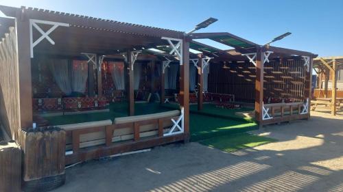 a wooden pavilion with a green lawn in a yard at Nabq Adventure Camp in Nabq