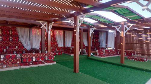 a living room with red chairs and a ceiling at Nabq Adventure Camp in Nabq
