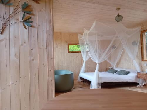a bedroom with a bed with a mosquito net at Hêtre sous le Charme in Saint-Martial-Entraygues