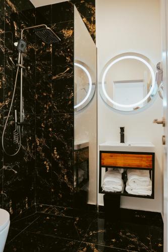 a bathroom with a sink and a shower and a mirror at Central 28 in Cluj-Napoca