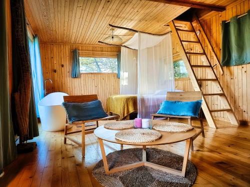 a room with a bed and a spiral staircase at Hêtre sous le Charme in Saint-Martial-Entraygues