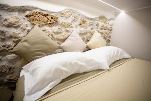 a bed with white sheets and pillows in a room at Borgo dei Papi in Anagni