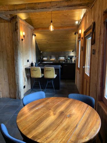 une salle à manger avec une table et des chaises en bois dans l'établissement Apartment Alys, contemporary style apartment in mountain village, à Abondance