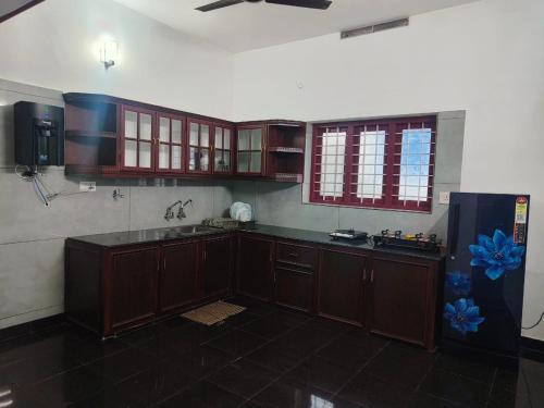 a kitchen with wooden cabinets and a black counter top at Palm Villa in Trichūr