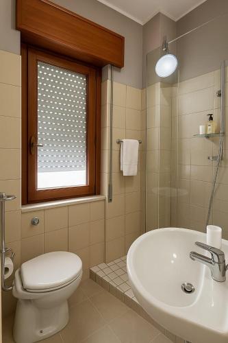a bathroom with a toilet and a sink and a window at SOGNO D'ESTATE 2 in Mazara del Vallo