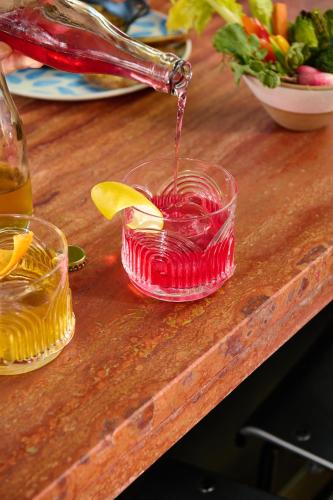 a drink being poured into a glass on a table at Populus Seattle in Seattle