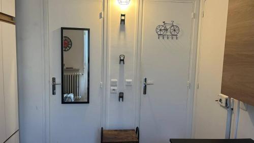 una porta bianca con uno specchio e una bicicletta sopra di apart 94160 studio a Saint-Mandé