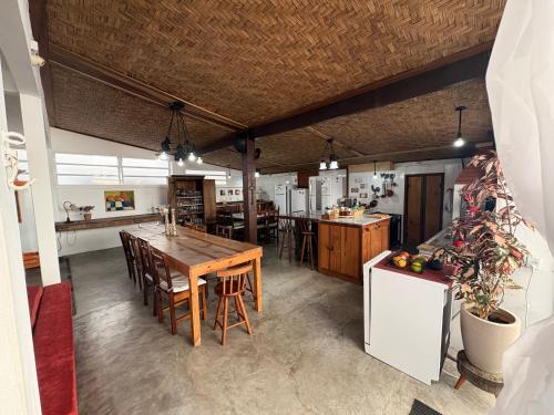 a large kitchen with a wooden table and chairs at Pousada Cantinho de Minas Da Tânia in Cabo Frio
