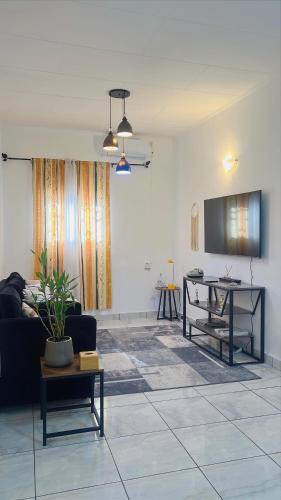 リーブルヴィルにあるMaison La Luciole LOUISのソファとテーブルのあるリビングルーム