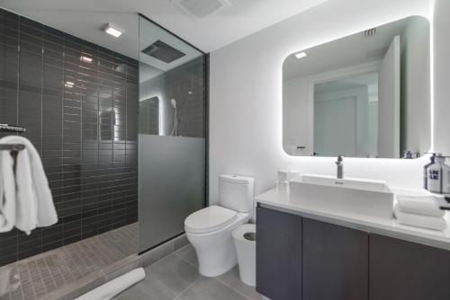 une salle de bain avec un lavabo, des toilettes et un miroir dans l'établissement Stylish Stay in the Heart of Miami - Walk to Bayside & Bayfront Park, à Miami